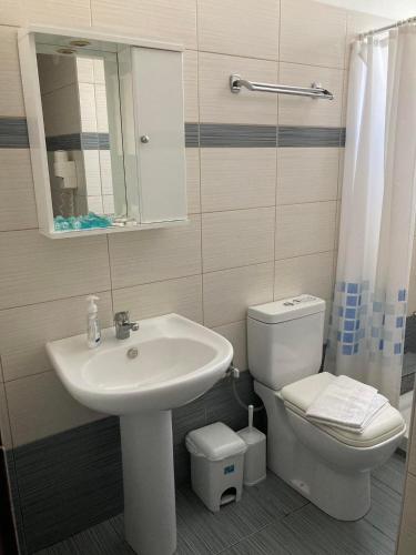 a bathroom with a sink and a toilet and a mirror at VILLA HARIKLIA in Paralia Katerinis
