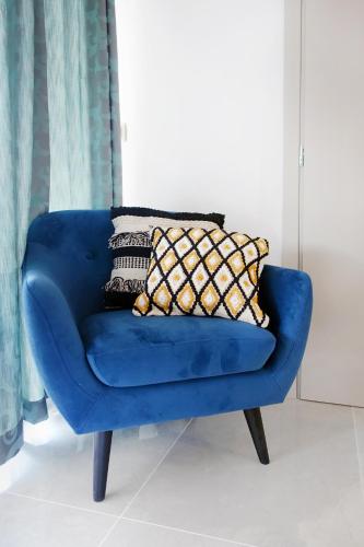 a blue chair with two pillows on top of it at Okean Apartments in Ierissos