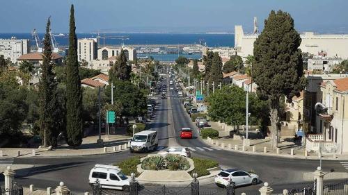 una strada cittadina con auto che percorrono una strada di City Port Hotel a Haifa