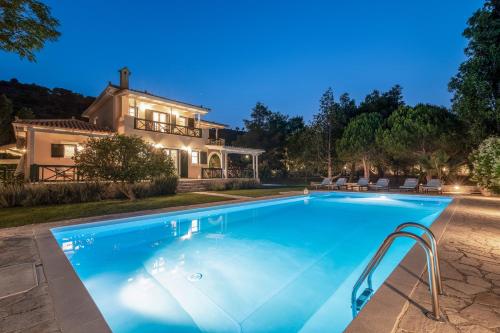 a swimming pool in front of a house at Villa Verdi - Your Family Oasis! in Vasilikos