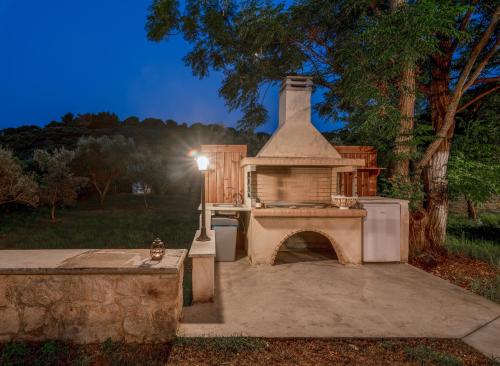 a outdoor kitchen with a fireplace in a yard at Villa Verdi - Your Family Oasis! in Vasilikos