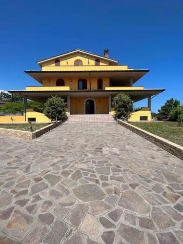 a large yellow house with a driveway in front of it at Villa Emma in Torrevecchia Teatina
