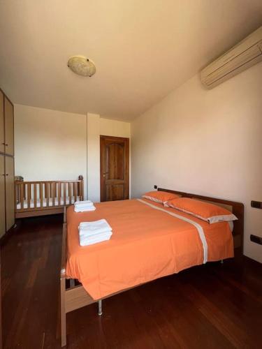 een slaapkamer met een oranje bed met handdoeken erop bij Villa Emma in Torrevecchia Teatina