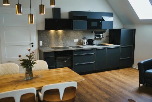 a kitchen with blue cabinets and a wooden table at Residence Black Eagle Lubmin Strand in Lubmin