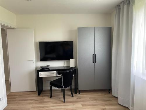 a room with a desk with a television and a cabinet at Dwa Żurawie - Głuszyn in Głuszyn