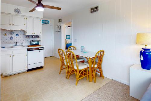 a kitchen with a dining room table and chairs at Southwinds, Unit H13 in Atlantic Beach