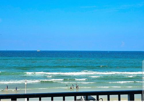 - un groupe de personnes sur la plage près de l'océan dans l'établissement Direct Oceanfront With Balcony, à Daytona Beach