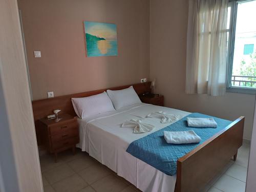 a bedroom with a bed with two towels on it at GIOTAS APARTMENTS - STUDIOS in Argalasti