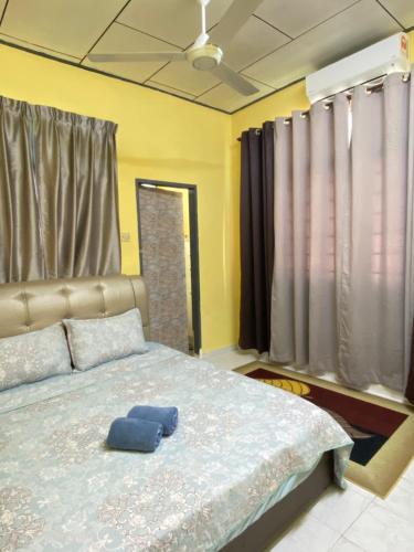 ein Schlafzimmer mit einem Bett mit zwei blauen Kissen darauf in der Unterkunft ELLY HOMESTAY in Kuala Terengganu