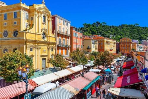 een uitzicht over de straat met winkels en gebouwen bij Beautiful flat with sunny balcony in heart of Nice Le Port in Nice