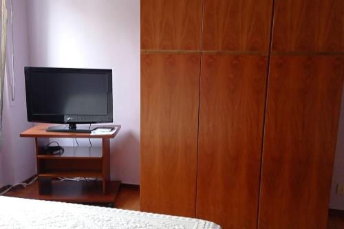 a bedroom with a large wooden cabinet with a television at appartamento incantevole a Ospedaletti(Sanremo) in Ospedaletti