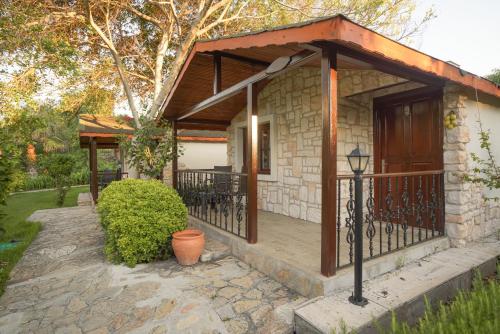 a stone house with a wooden gate and a porch at Datça Dirik Surf Beach Hotel in Datca