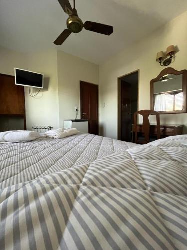 a bedroom with a large bed with a ceiling fan at Hotel Catedral in Luján