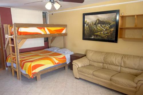 a bedroom with a bunk bed and a couch at Hotel Los Burritos in Puerto Chicama