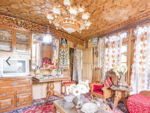 een woonkamer met een bank, een tafel en een tv bij New Minar Group Of houseboats in Srinagar