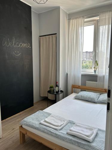 a bedroom with two beds and a chalkboard on the wall at Sunhaus in Gdynia