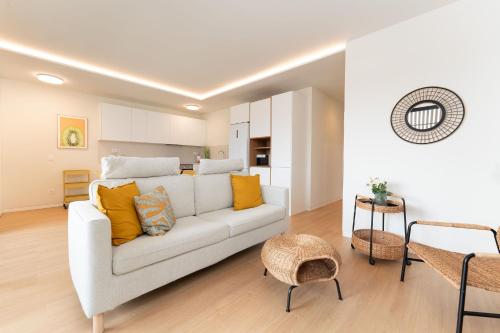 a living room with a white couch and yellow pillows at Apartamento Roca Paraíso De Agaete Con Vistas Panorámicas in Agaete