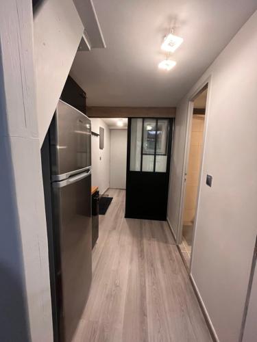 a hallway leading to a kitchen with a refrigerator at Le Petit Chalet Addicted to Paradise in Tignes