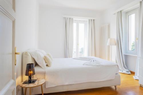 - une chambre blanche avec un lit blanc et des fenêtres dans l'établissement Villa Magnolia - High standing floor, à Locarno