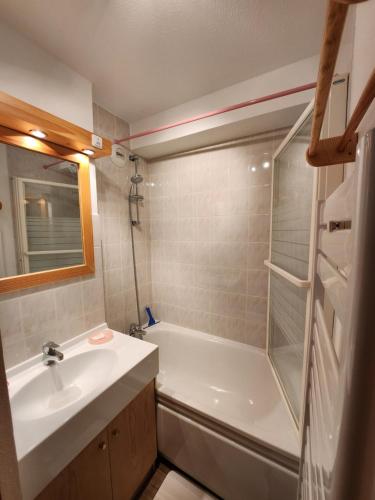 uma casa de banho com uma banheira, um lavatório e um chuveiro em Cocon à chatel em Châtel