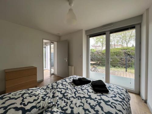 a bedroom with a bed and a large window at La terrasse des Thermes, Jura in Lons-le-Saunier
