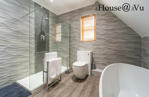 a bathroom with a shower and a toilet and a sink at The Hoose at The Vu in Bathgate