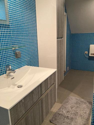 uma casa de banho com lavatório e azulejos azuis em Gastroatelier em Gooik