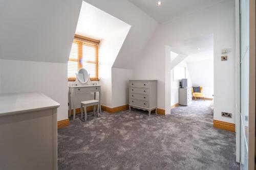 an attic room with a desk and a dresser at The Hoose at The Vu in Bathgate