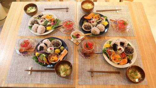 una mesa con platos de comida en una mesa con palillos en お宿 TSURUYA, en Sasebo