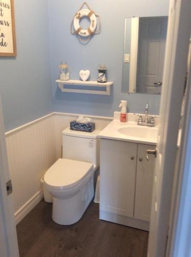 a bathroom with a toilet and a sink and a mirror at Chambre confortable in Sherbrooke