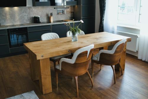 a wooden table with chairs and a vase of flowers on it at Residence Black Eagle Lubmin Strand in Lubmin