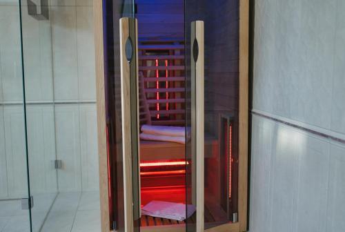 a glass cabinet with red towels in a room at Residence Black Eagle Lubmin Strand in Lubmin