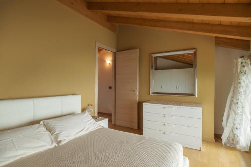 a bedroom with a bed and a dresser and a mirror at Appartamento Vittoria in Parzanica