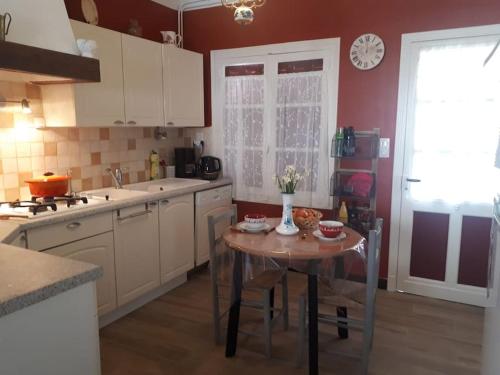 une cuisine avec une petite table au milieu dans l'établissement La maison de Nestalas, à Pierrefitte-Nestalas