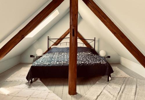 ein Schlafzimmer mit einem Himmelbett im Dachgeschoss in der Unterkunft Chalet Sch-l-afbock in Markranstädt