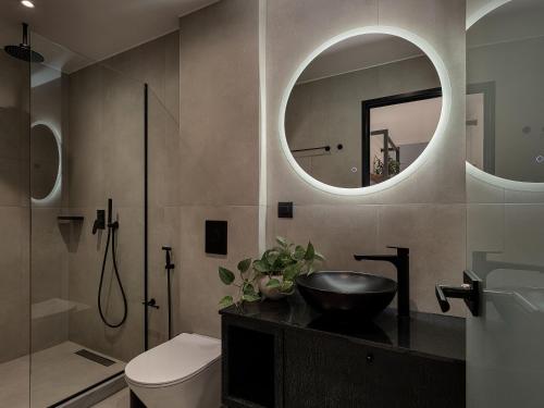 a bathroom with a sink and a toilet and a mirror at Theta Boutique Hotel in Chania