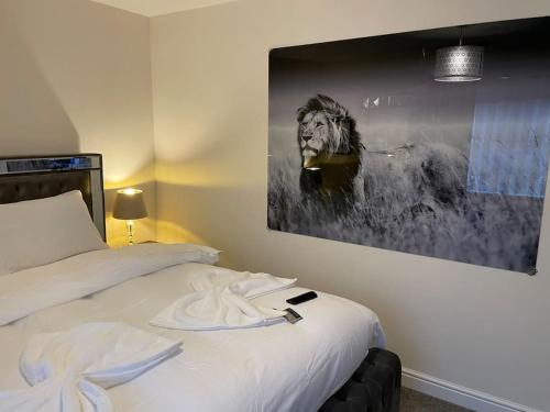um quarto com uma cama com uma pintura de um leão em MODERN 4 BEDROOM HOUSE WITH GARDEN & PARKING em Swanscombe