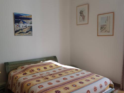 un lit dans une chambre avec deux tableaux au mur dans l'établissement HAUT STANDING, à Ajaccio