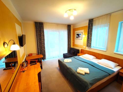 a hotel room with a bed and a couch at Rezydencja 5 Dębów in Międzyzdroje