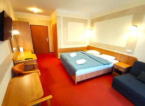 a hotel room with a bed and a couch at Rezydencja 5 Dębów in Międzyzdroje