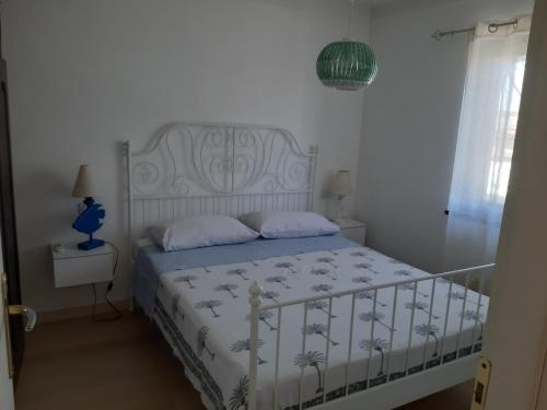 ein Schlafzimmer mit einem weißen Bett mit einer weißen Tagesdecke in der Unterkunft Villa Colle Circeo 1° in San Felice Circeo