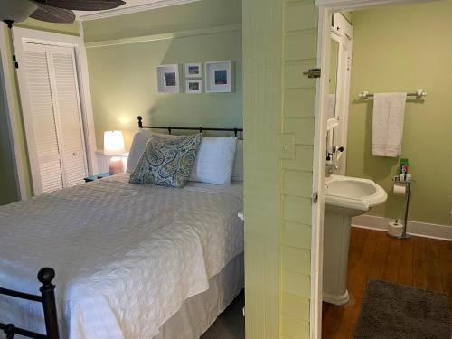 a bedroom with a bed and a sink and a bathroom at 3BR/3BA Charming Key West Style Home in Downtown Saint Augustine in Saint Augustine