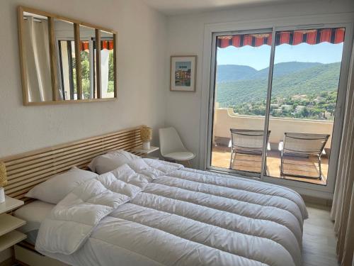 une chambre avec un grand lit et une grande fenêtre dans l'établissement Bastide 2 chambres - Piscine - Vue Mer - Wifi - 2 SDB, à La Croix-Valmer
