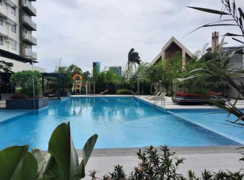 a large swimming pool in the middle of a building at Mesatierra Garden Residences - Condo in Davao City