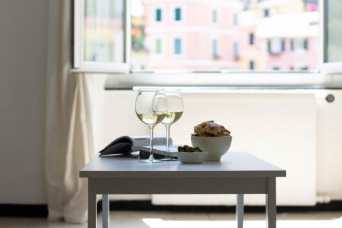 a table with two wine glasses and a bowl of food at Blue by PortofinoHomes in Portofino