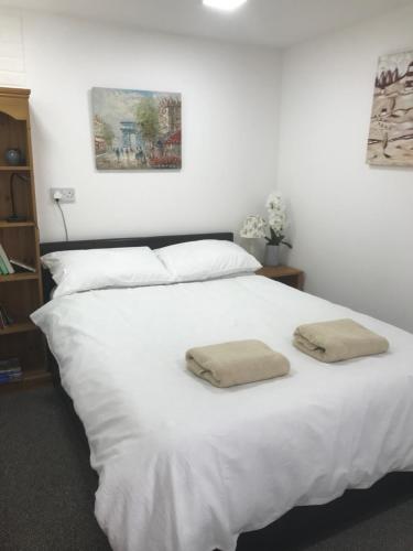 a white bed with two towels on top of it at Annexe in lymington with private use of hot tub in Everton