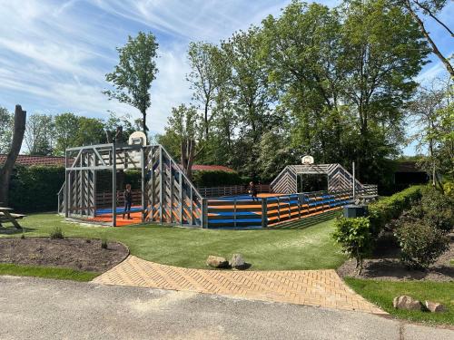 plac zabaw w parku z ludźmi grającymi na nim w obiekcie BadHoophuizen 6-per Bungalow Veluwemeer Trampoline w mieście Hulshorst