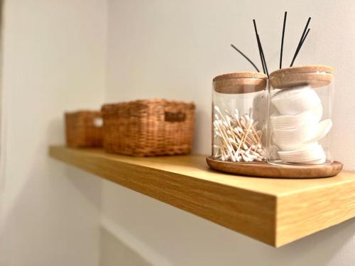 a shelf with a glass jar and baskets on it at Cosy apartment in town centre in Finedon