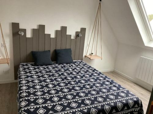 een slaapkamer met een groot bed met blauwe kussens bij Gite sur ferme equestre in Pouldreuzic
