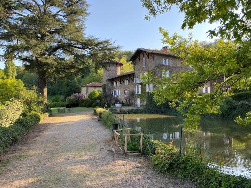 un antiguo edificio junto a un río con una casa en Manoir de Tourville, en Les Halles